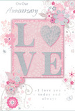 This anniversary card is a gentle celebration of enduring romance, its colours and composition echoing the quiet charm of Leamouth's riverside paths. The central focus is the word LOVE, set in raised capitals with a soft, glittering surface that shimmers delicately as the light moves across it. In a tender twist, the O is replaced by a small heart, filled with slightly denser silver glitter, making it the brightest point in the design and emphasizing the emotional core of the message. Surrounding this central word, clusters of delicate flowers in blush pink and muted mauve open softly, their petals shaded with a watercolor-like touch. Fine, flowing lines suggest stems and leaves, curling around the blooms in gentle arcs reminiscent of floral arrangements created for anniversaries in nearby Leamouth homes. Light grey and silver accents thread through the design, adding subtle highlights that feel like glints of sunlight on the water by Trinity Buoy Wharf. Tiny flourishes-floating petals, slim swirls, and almost translucent butterflies-add a sense of movement, as if a mild spring breeze were passing through an English garden. The background remains a soft, pastel pink, smooth and tranquil, allowing the glittered LOVE and elegant florals to stand out clearly. Elegant script phrases such as On Our Anniversary and I love you today and always are placed thoughtfully around the central motif, their flowing letters complementing the curves of the vines. Overall, the card feels like a whispered promise captured on paper, as delicately crafted as a bespoke anniversary bouquet prepared for delivery across Leamouth, and just as capable of conveying deeply felt affection.